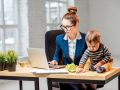 Multitasking businesswoman with her son working at the office