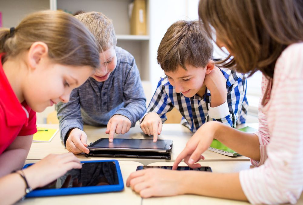 group of school kids with tablet pc in classroom