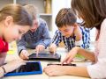 group of school kids with tablet pc in classroom