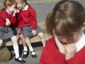 Female Elementary School Pupils Whispering In Playground