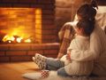 family mother and child hugs and warm on winter evening by fireplace