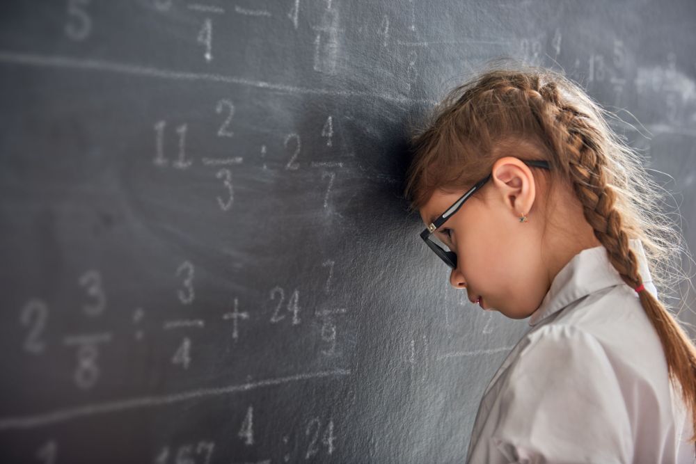 Sad child near the blackboard