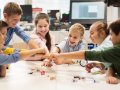 happy children making fist bump at robotics school