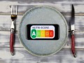 Viersen, Germany - February 9. 2021: Closeup of smartphone screen with logo lettering of nutri-score on plate with cutlery