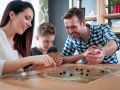 Happy family playing board game at home