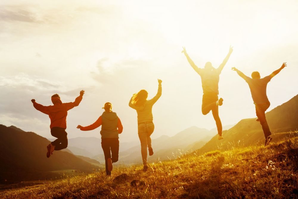 Group of happy friends run and jump