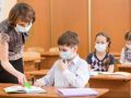 school kids and teacher with protection mask against flu virus at lesson