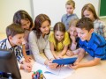 group of kids with teacher and tablet pc at school