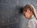 Sad child near the blackboard