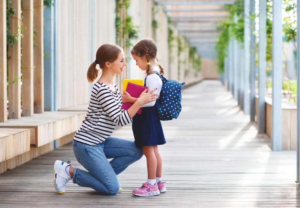 first day at school. mother leads  little child school girl in first grade