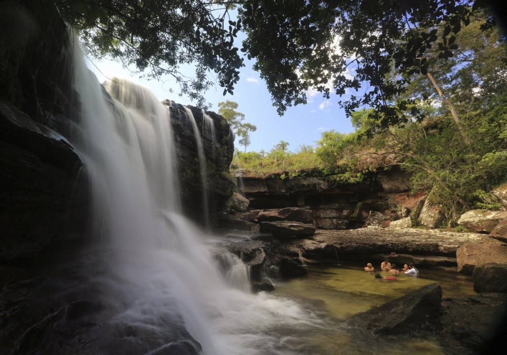 tourists-bathe-at-the-el-cuarzo-waterfall-locally-referred-to-as-the-river-of-five-colors-in-cano-cristales-in-the-colombias-sierra-de-la-macarena-national-park.jpg